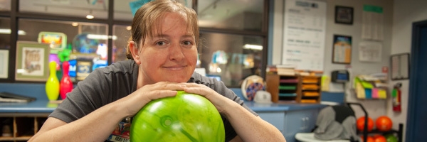 woman posing near bowling ball