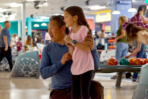 Man and daughter bowling